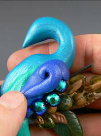 Blue molded clay being added to clay peacock